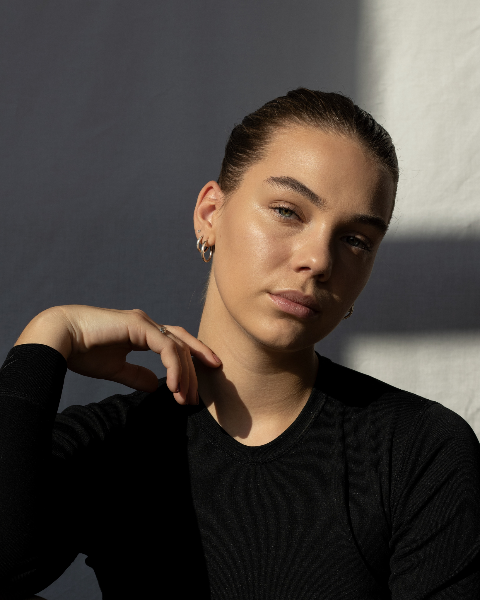 Profile of woman with slick-back hair and glowy complexion