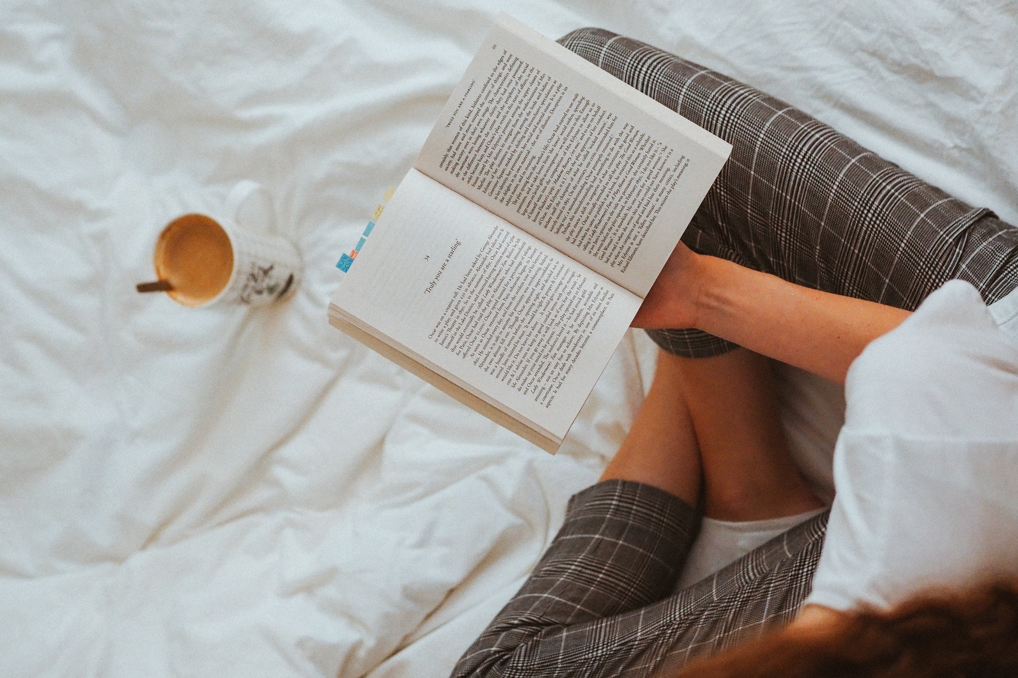 Best books for PCOS: person on bed with book and tea