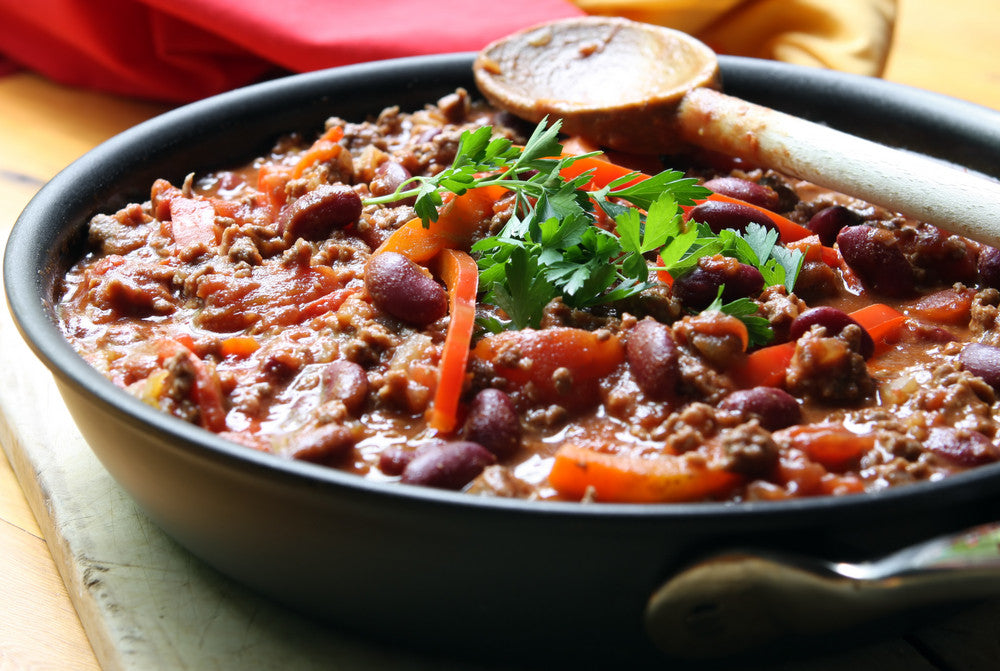 Three Bean Chilli in a bowl with a wooden spoon