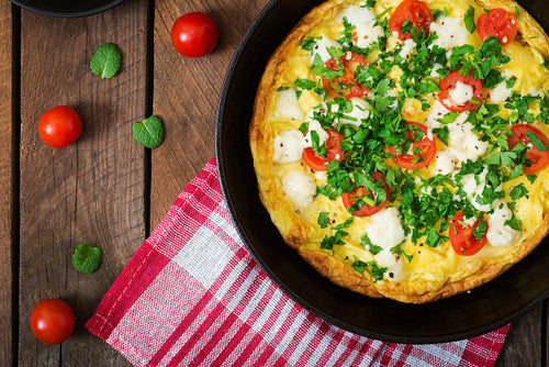Feta, tomato and mint omelette on a wooden table