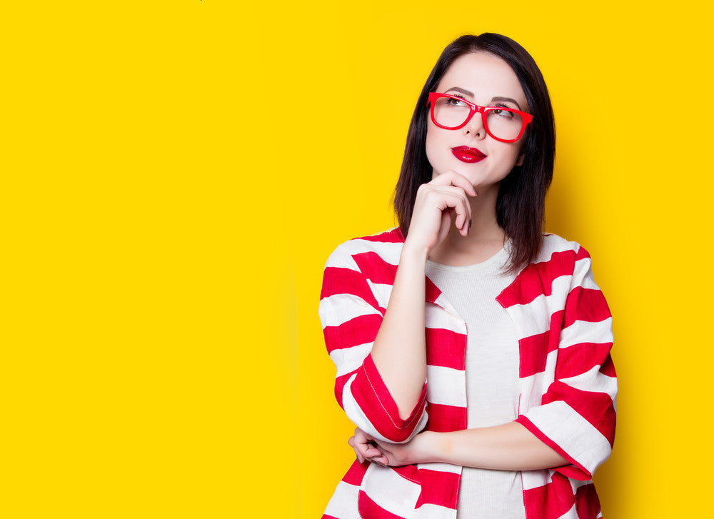 Woman thinking about PCOS against a yellow background