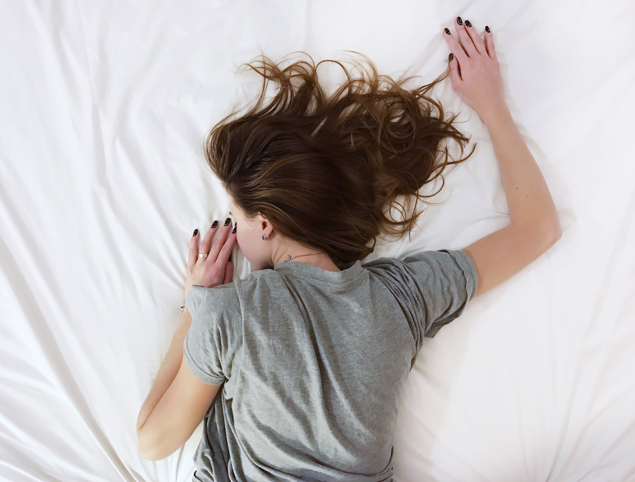 Period pain relief: woman lying face down on bed